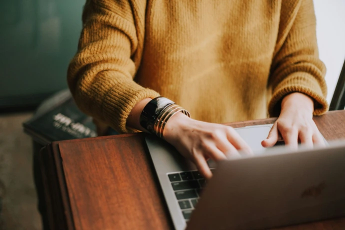 une dame qui tape sur son clavier d'ordinateur