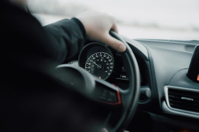 une main sur un volant de voiture en marche