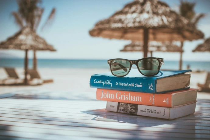 lunettes de soleil posées sur une pile de livres à la plage